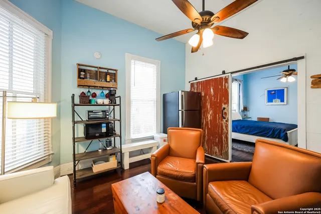 a living room with furniture a ceiling fan and a window