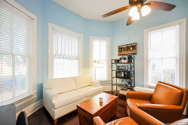 a living room with furniture a bookshelf and a window