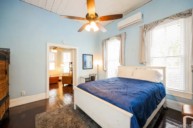 a spacious bedroom with a large bed a chandelier and a window