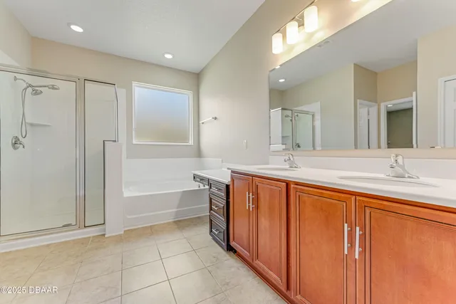 a spacious bathroom with a double vanity sink a mirror and a bathtub