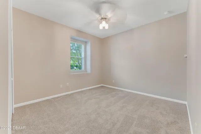 an empty room with windows and ceiling fan