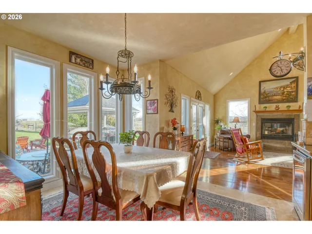 a dining room with furniture a chandelier and wooden floor