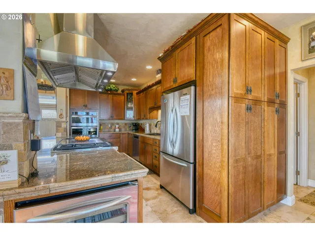 a kitchen with stainless steel appliances granite countertop a refrigerator and a sink