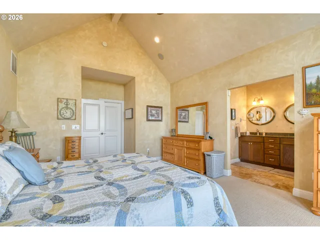 a bedroom with a bed and dresser with mirror