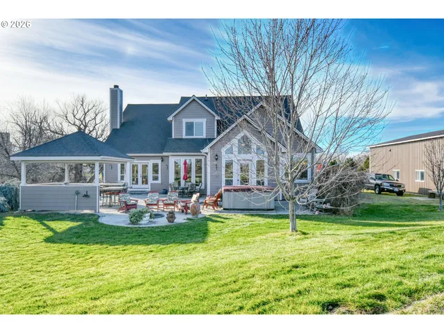 a view of a house with backyard and sitting area