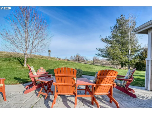 a view of a backyard with table and chairs under an umbrella