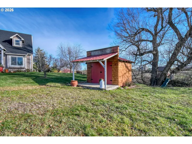 a view of a house with a big yard and a large tree