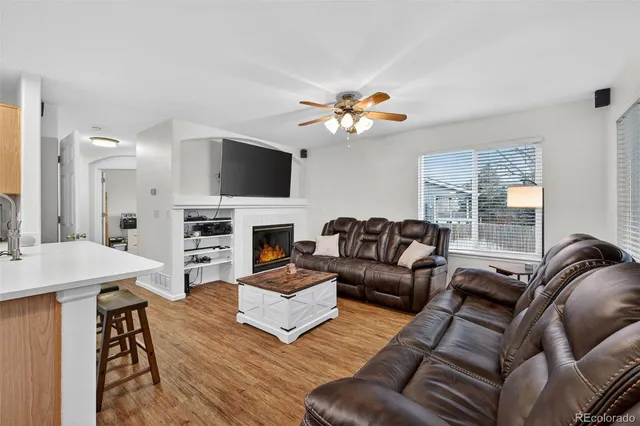 a living room with furniture a fireplace and a flat screen tv