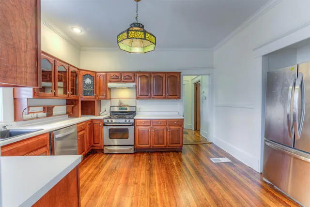 a kitchen with stainless steel appliances granite countertop a stove refrigerator and cabinets
