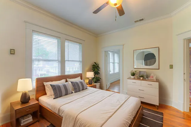 a bedroom with a bed and wooden floor
