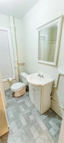 a bathroom with a sink mirror and toilet