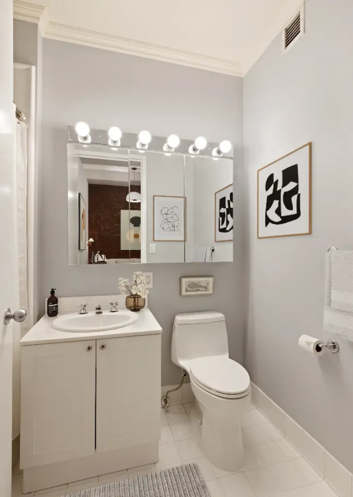 252 7th Avenue, Unit 5T Manhattan, NY 10001 - Photo 2 of 7 a bathroom with a toilet a sink and mirror