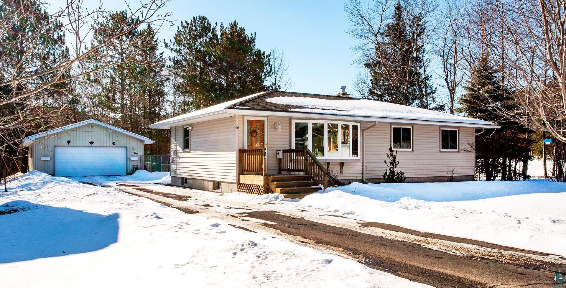 Ranch-style house with a garage and an outbuilding