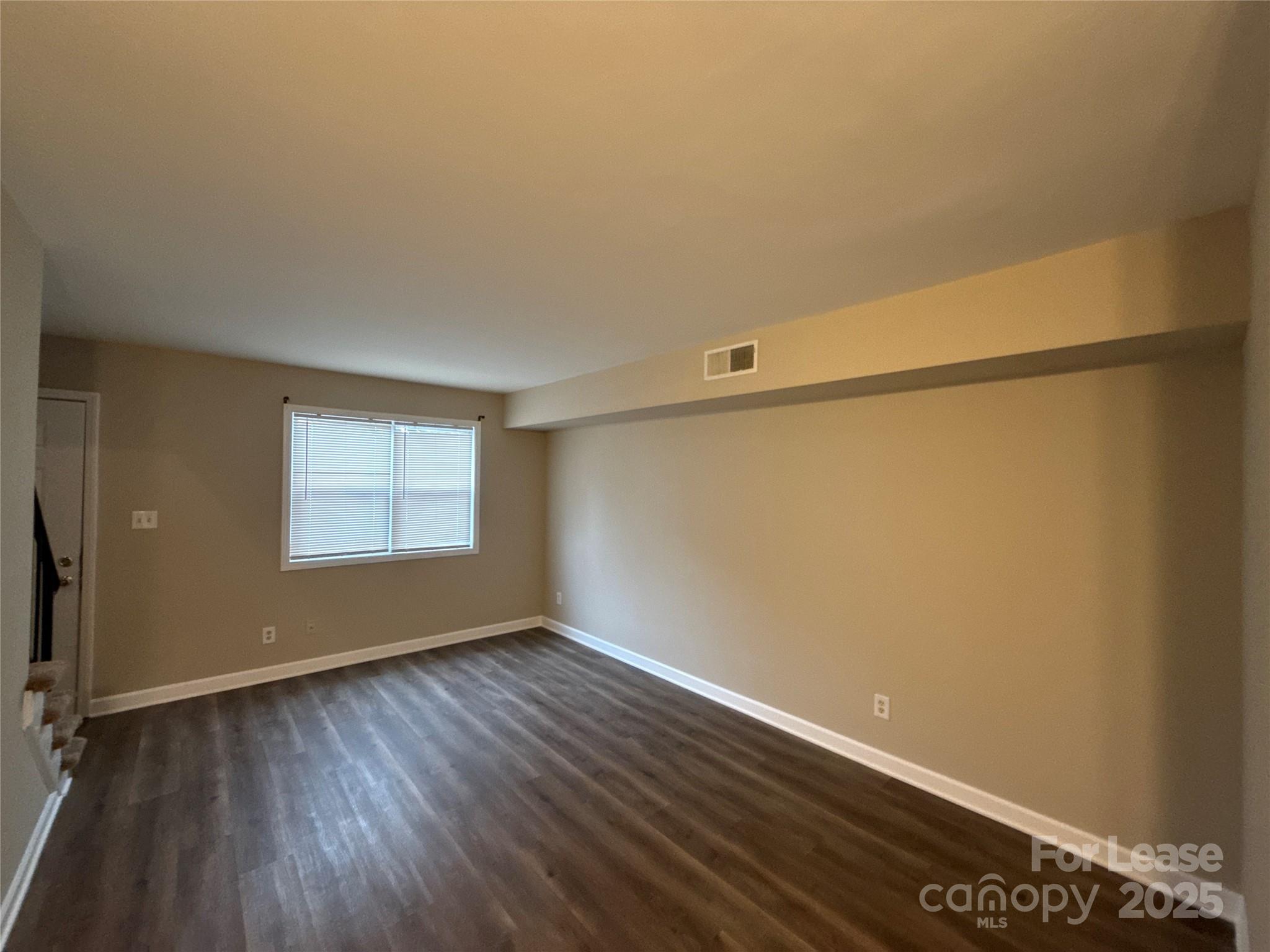 1613 North Sharon Amity Road, Unit H Charlotte, NC 28205 - Photo 4 of 13 a view of an empty room with wooden floor and a window