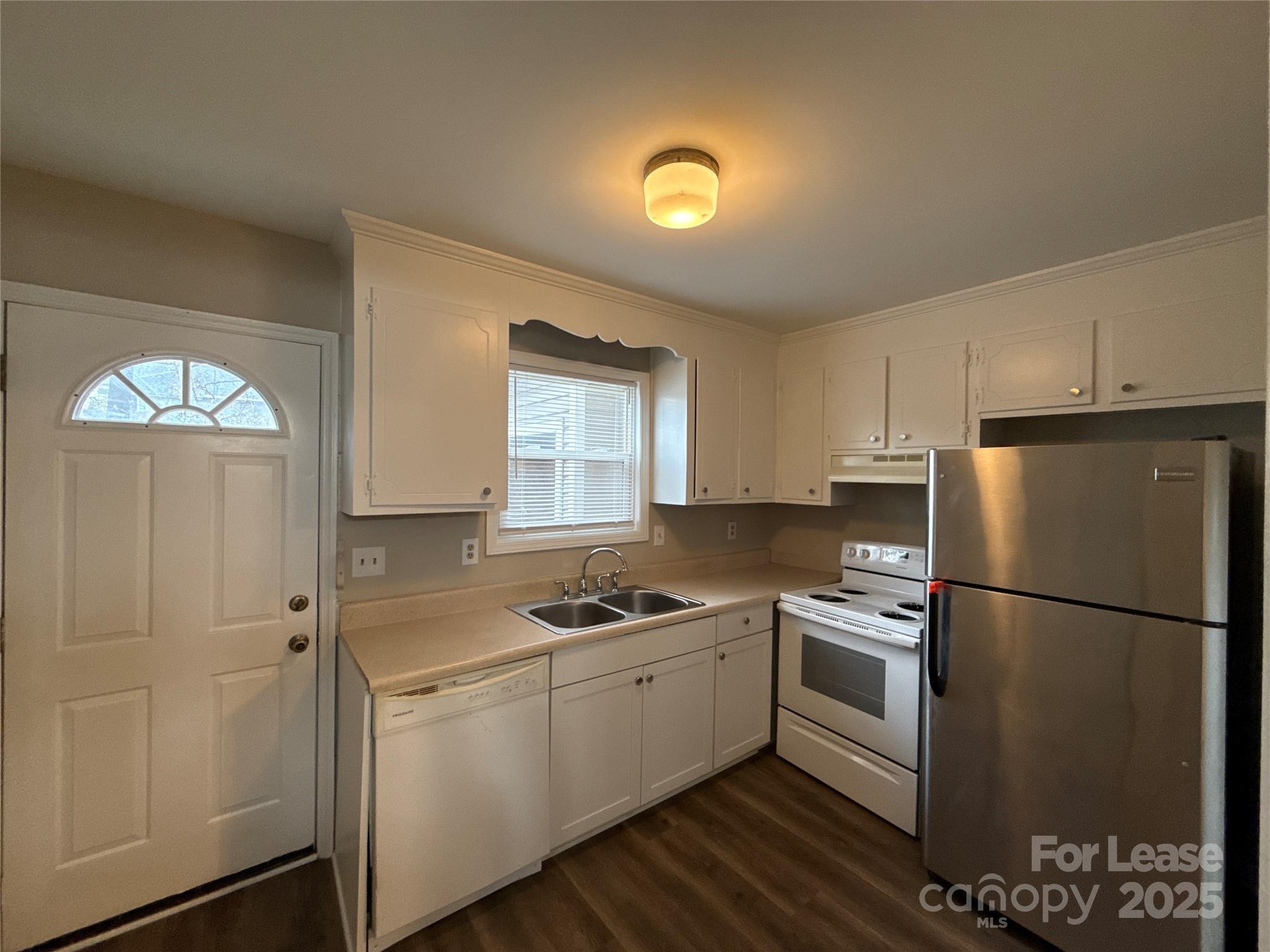 1613 North Sharon Amity Road, Unit H Charlotte, NC 28205 - Photo 5 of 13 a kitchen with a refrigerator a stove cabinets and wooden floor