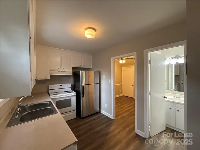 a kitchen with stainless steel appliances granite countertop a refrigerator and a stove