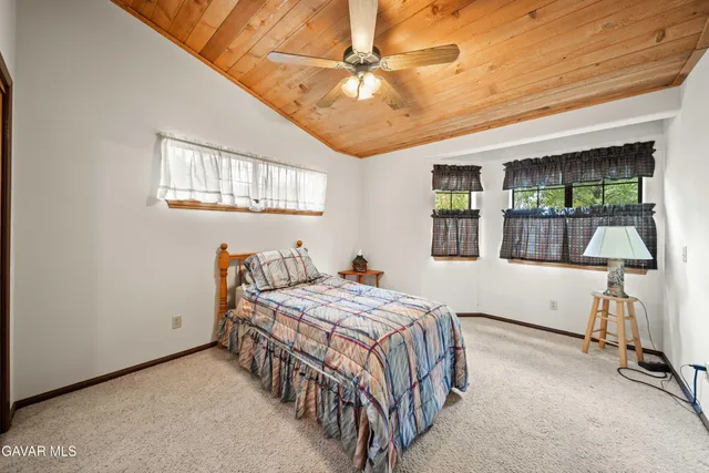 a bedroom with a bed a table and windows