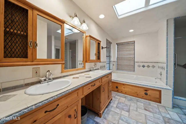 a spacious bathroom with a granite countertop sink mirror and a bath tub