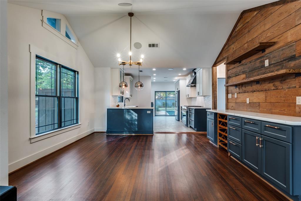 5819 Prospect Avenue Dallas, TX 75206 - Photo 7 of 25 a open kitchen with stainless steel appliances granite countertop a refrigerator a oven a large island with wooden floors and couches