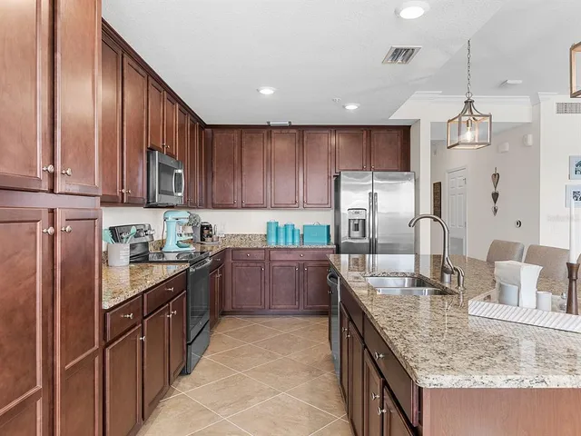 a kitchen with granite countertop a sink stove and refrigerator