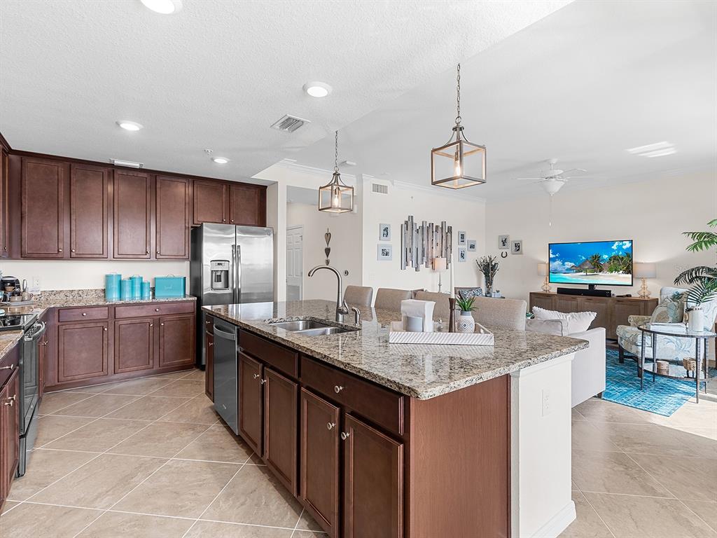 17108 Vardon Terrace, Unit 203 Lakewood Ranch, FL 34211 - Photo 16 of 50 a kitchen with stainless steel appliances granite countertop a sink counter space cabinets and a wooden floor