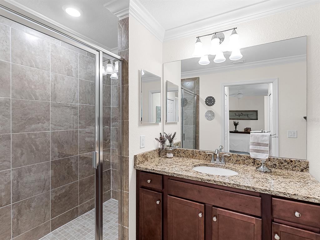 17108 Vardon Terrace, Unit 203 Lakewood Ranch, FL 34211 - Photo 25 of 50 a bathroom with a granite countertop sink a mirror and a shower