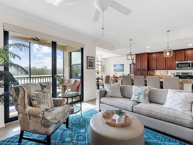 a living room with furniture kitchen and a large window