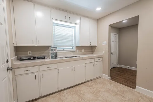 a kitchen with granite countertop white cabinets and a stove