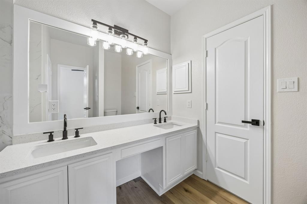 13347 Dove Ranch Road Fort Worth, TX 76262 - Photo 21 of 30 Dual vanity with integrated sinks, white cabinetry, a spacious countertop, and wood-finish flooring