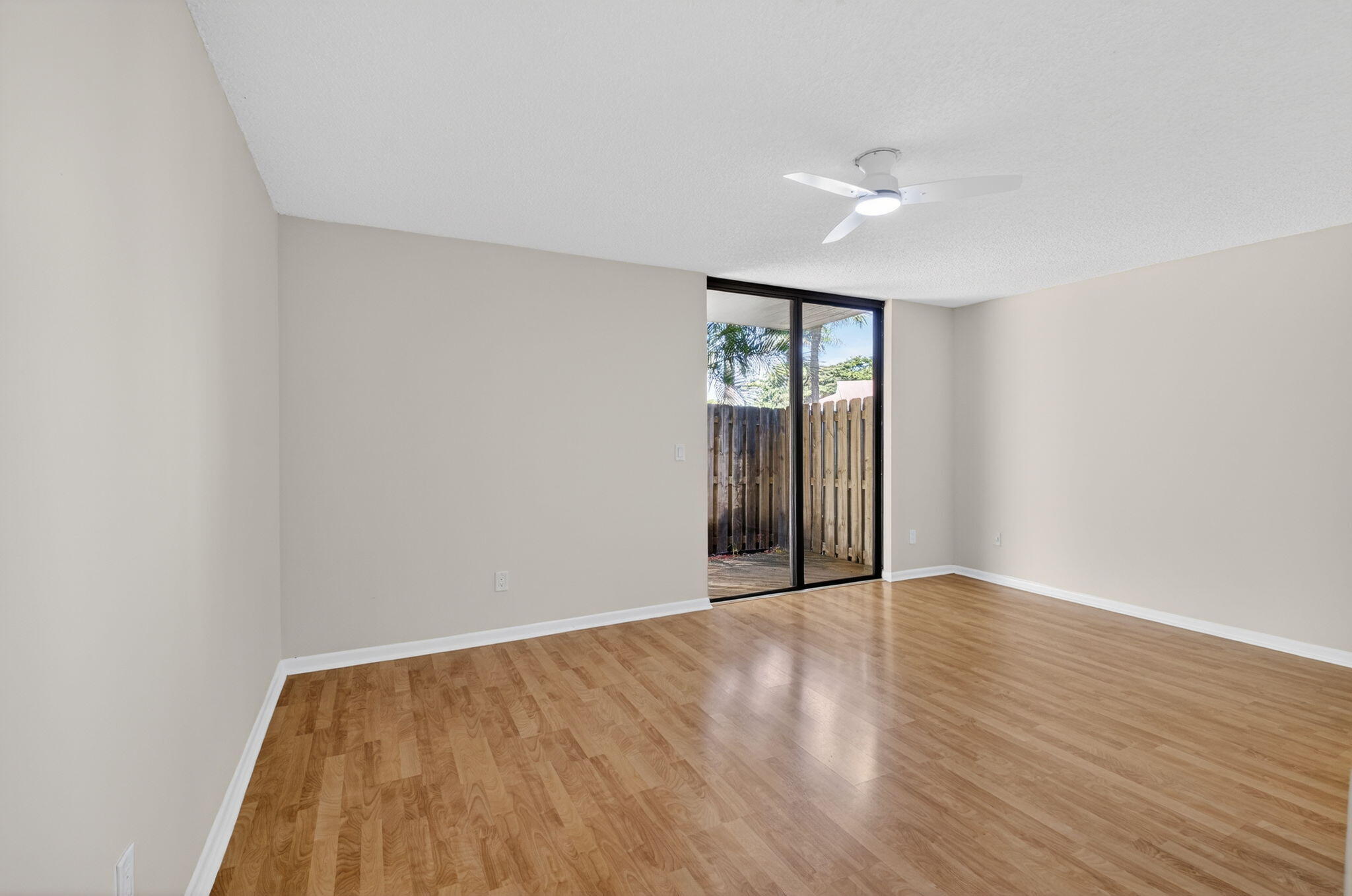 5845 Fox Hollow Drive, Unit A Boca Raton, FL 33486 - Photo 12 of 50 a view of an empty room with wooden floor and a window