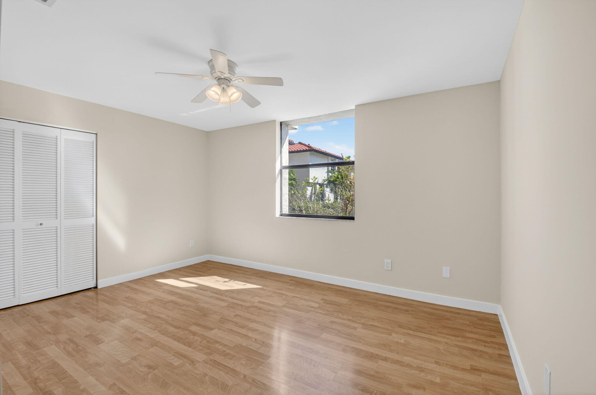 5845 Fox Hollow Drive, Unit A Boca Raton, FL 33486 - Photo 17 of 50 an empty room with wooden floor ceiling fan and windows