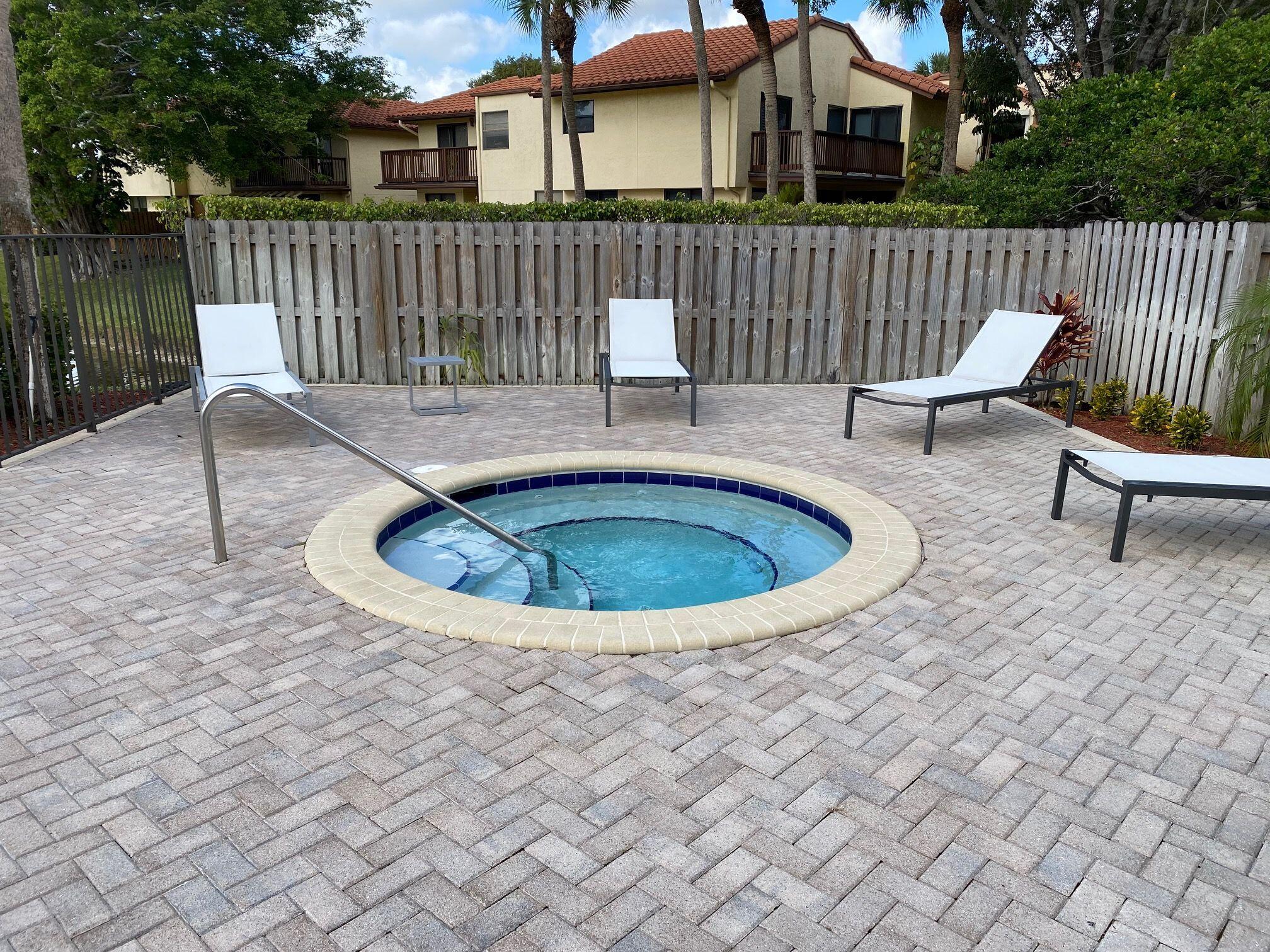 5845 Fox Hollow Drive, Unit A Boca Raton, FL 33486 - Photo 33 of 50 a view of a chair and table in the back yard of the house