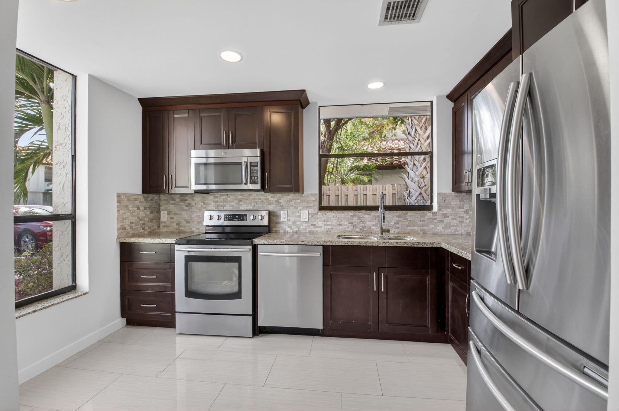 5845 Fox Hollow Drive, Unit A Boca Raton, FL 33486 - Photo 4 of 50 a kitchen with stainless steel appliances granite countertop a stove and a refrigerator