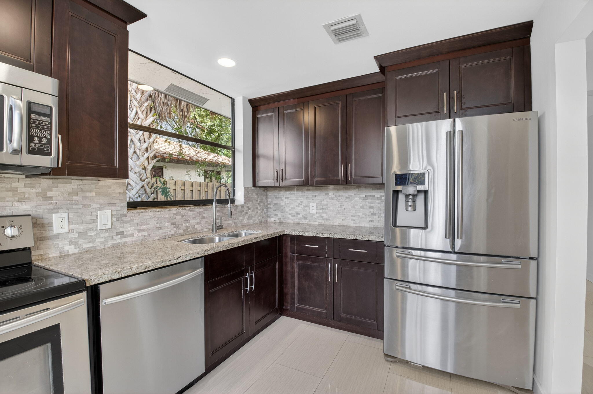 5845 Fox Hollow Drive, Unit A Boca Raton, FL 33486 - Photo 5 of 50 a kitchen with stainless steel appliances granite countertop a refrigerator sink and cabinets