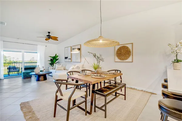 a view of a dining room and livingroom with furniture wooden floor a chandelier