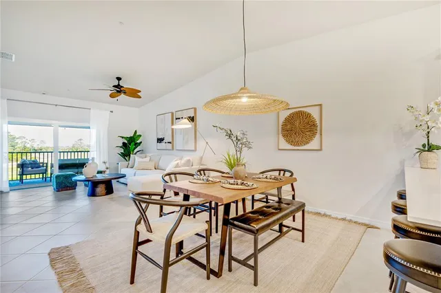 a view of a dining room and livingroom with furniture wooden floor a chandelier