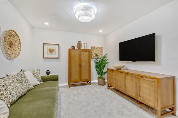 a bedroom with a bed and a flat tv screen on dresser