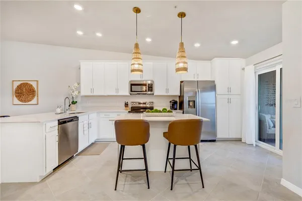 a kitchen with kitchen island white cabinets and stainless steel appliances