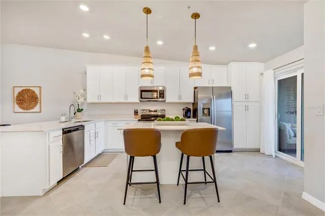 a kitchen with kitchen island white cabinets and stainless steel appliances