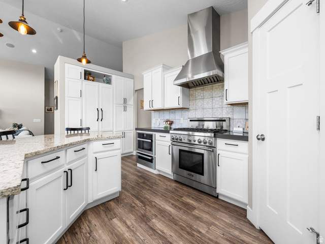 7 Sterling Loop Vineyard, UT 84059 - Photo 14 of 43 Kitchen featuring a stainless steel professional-grade range, coordinating range hood, and integrated microwave