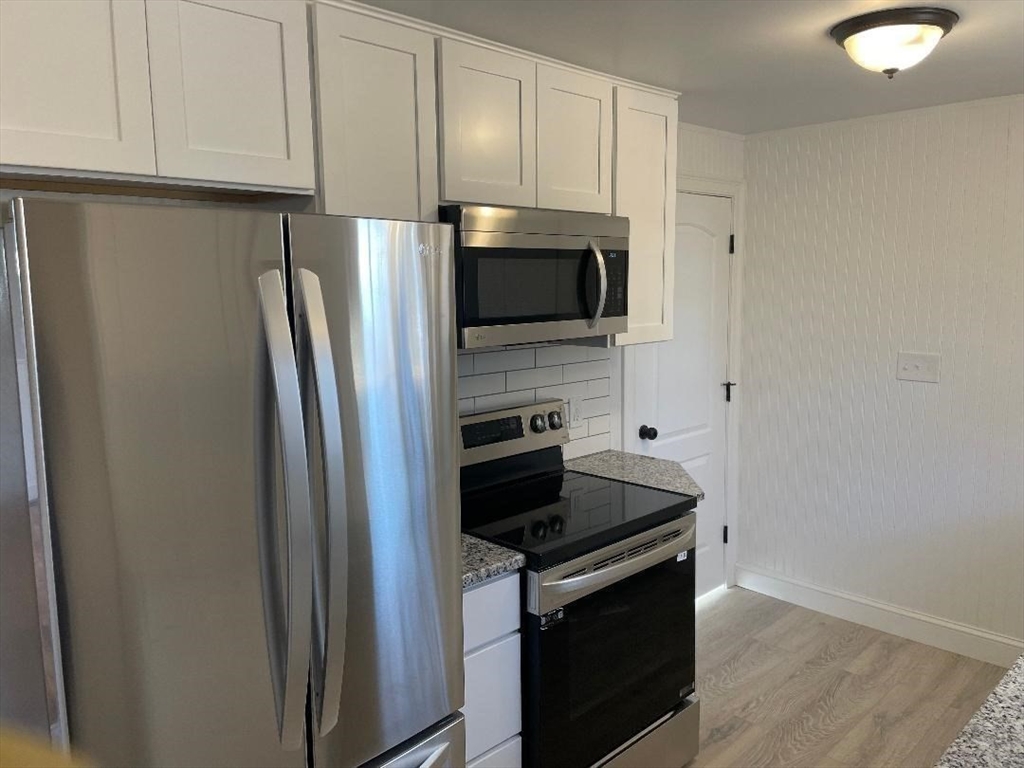 210 Navajo Road Springfield, MA 01109 - Photo 8 of 38 a kitchen with granite countertop a refrigerator stove and microwave