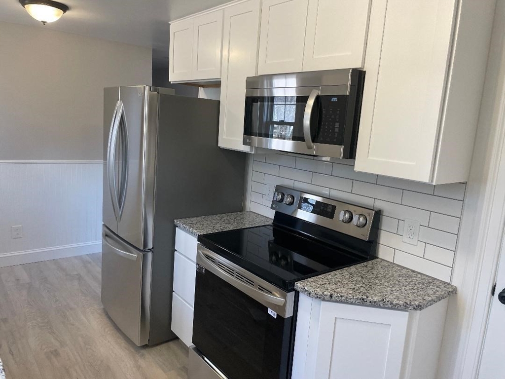 210 Navajo Road Springfield, MA 01109 - Photo 9 of 38 a kitchen with stainless steel appliances granite countertop a refrigerator stove and microwave