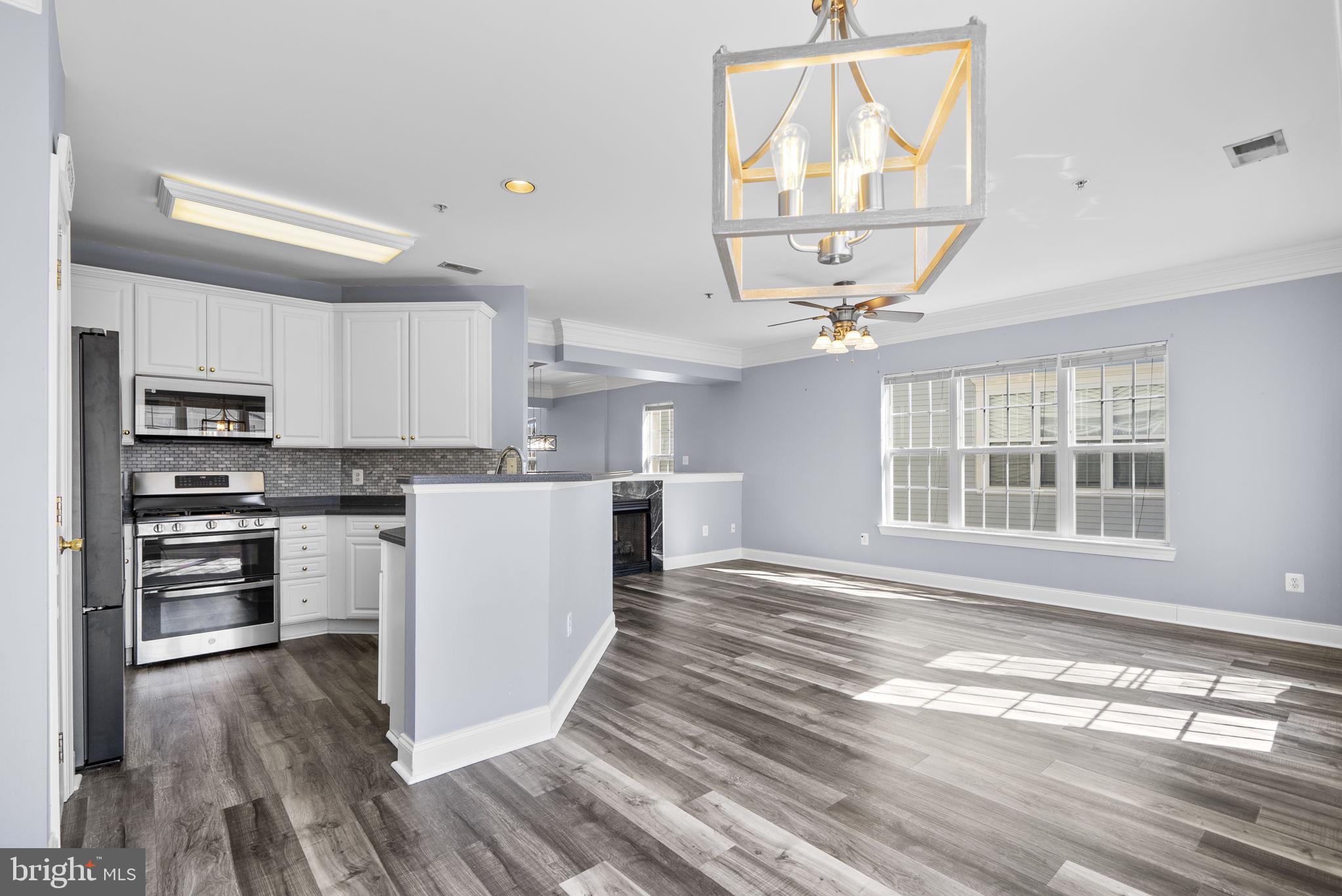 932 Orchard Ridge Drive, Unit 200 Gaithersburg, MD 20878 - Photo 23 of 51 a kitchen with kitchen island wooden floors appliances and cabinets