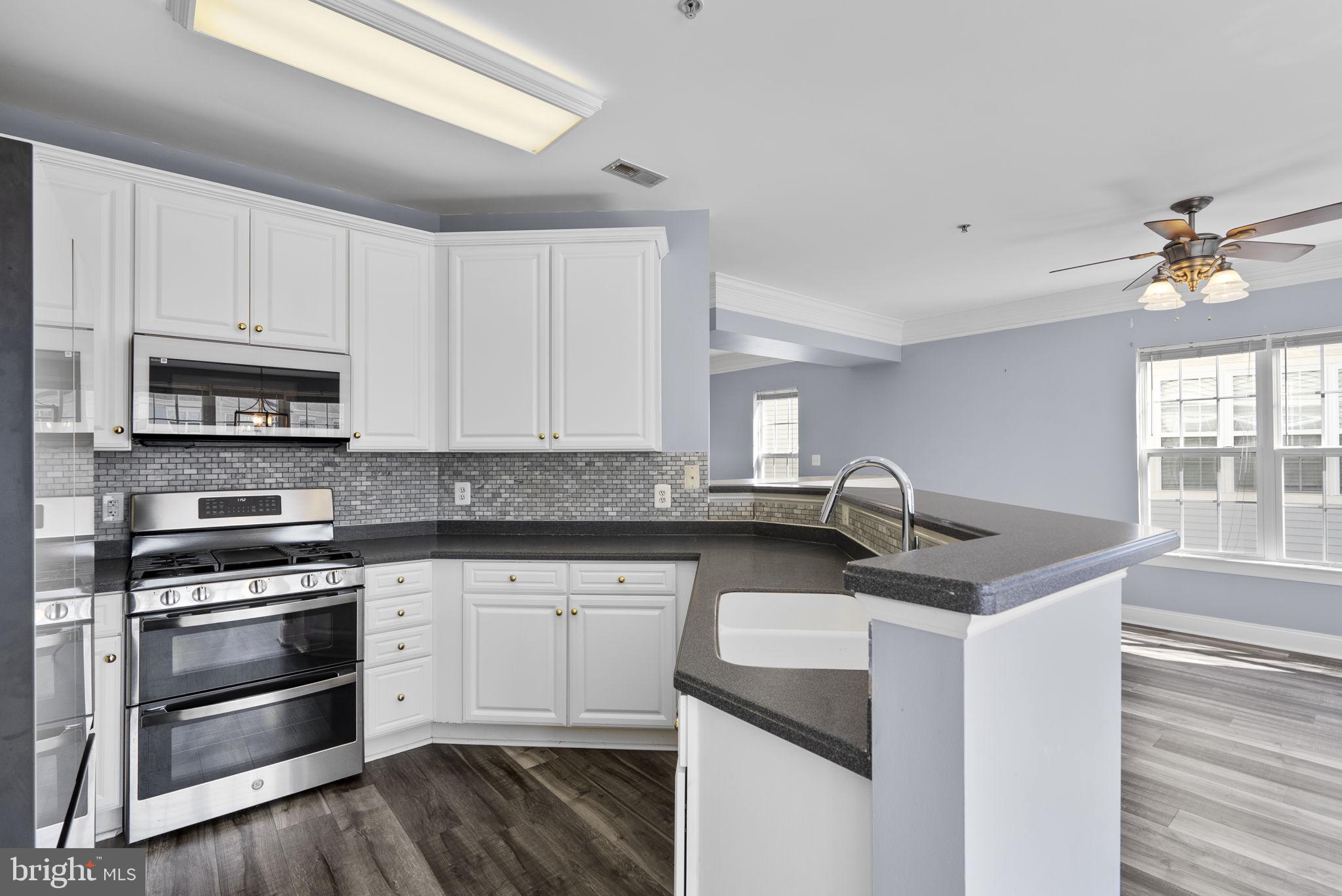 932 Orchard Ridge Drive, Unit 200 Gaithersburg, MD 20878 - Photo 24 of 51 a kitchen with stainless steel appliances granite countertop a sink stove and cabinets