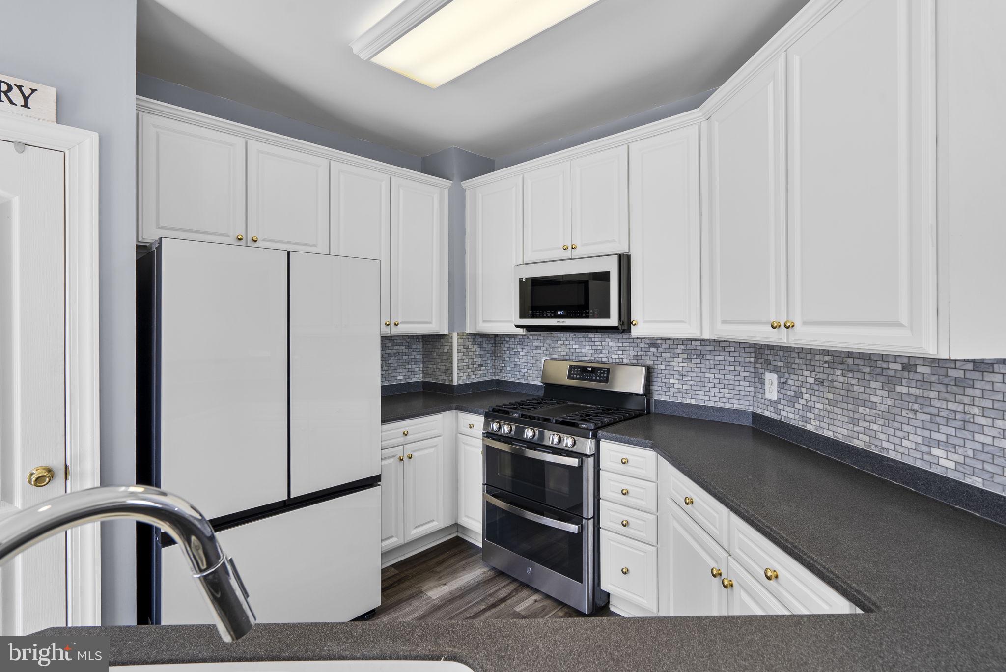 932 Orchard Ridge Drive, Unit 200 Gaithersburg, MD 20878 - Photo 25 of 51 a kitchen with white cabinets stainless steel appliances and sink