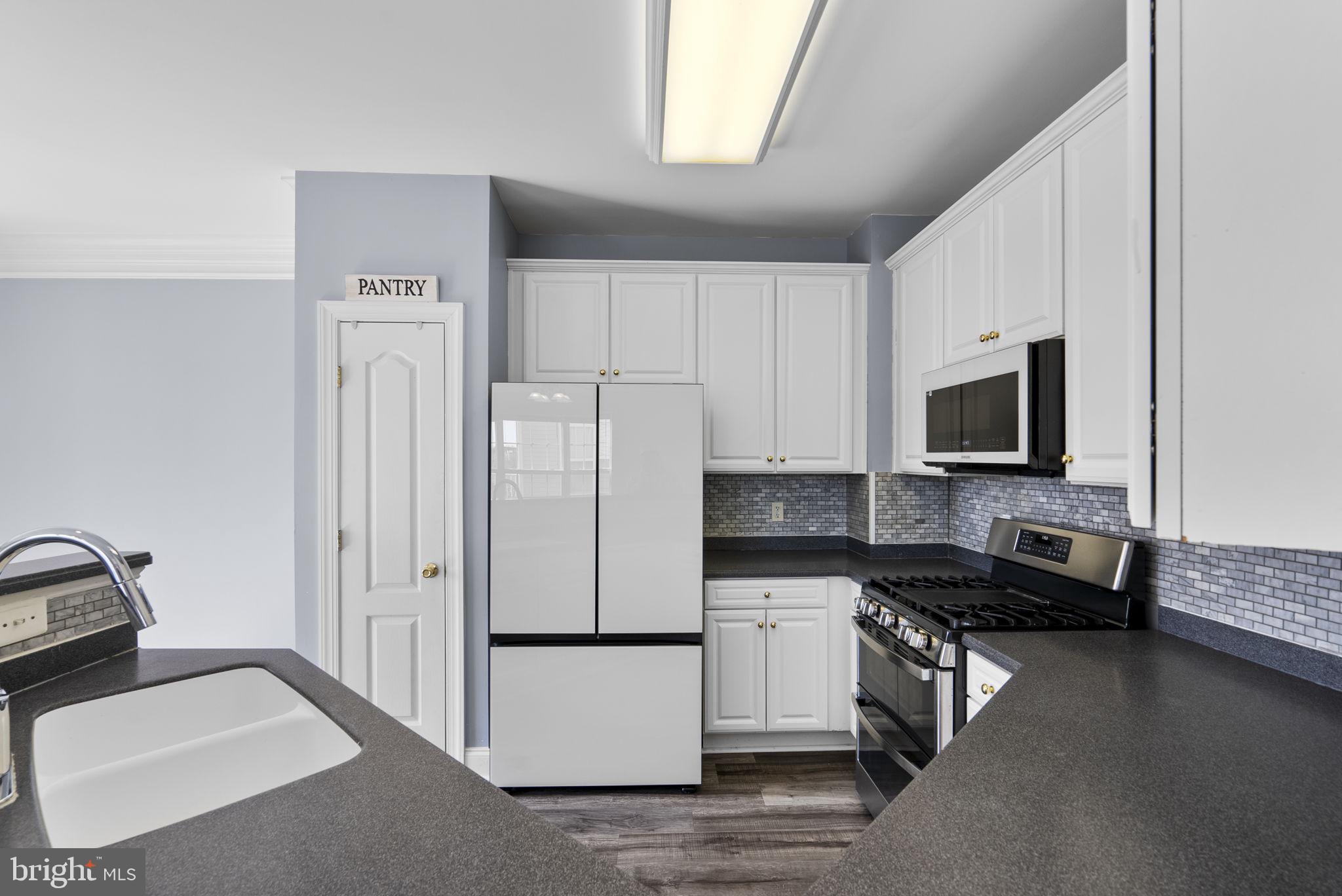 932 Orchard Ridge Drive, Unit 200 Gaithersburg, MD 20878 - Photo 26 of 51 a kitchen with stainless steel appliances a refrigerator stove and sink