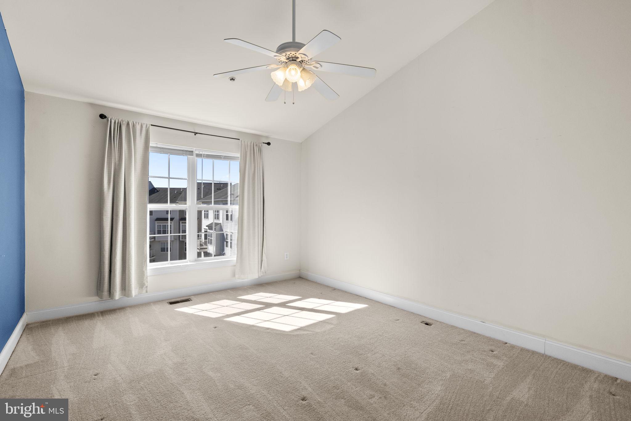 932 Orchard Ridge Drive, Unit 200 Gaithersburg, MD 20878 - Photo 39 of 51 an empty room with windows and ceiling fan