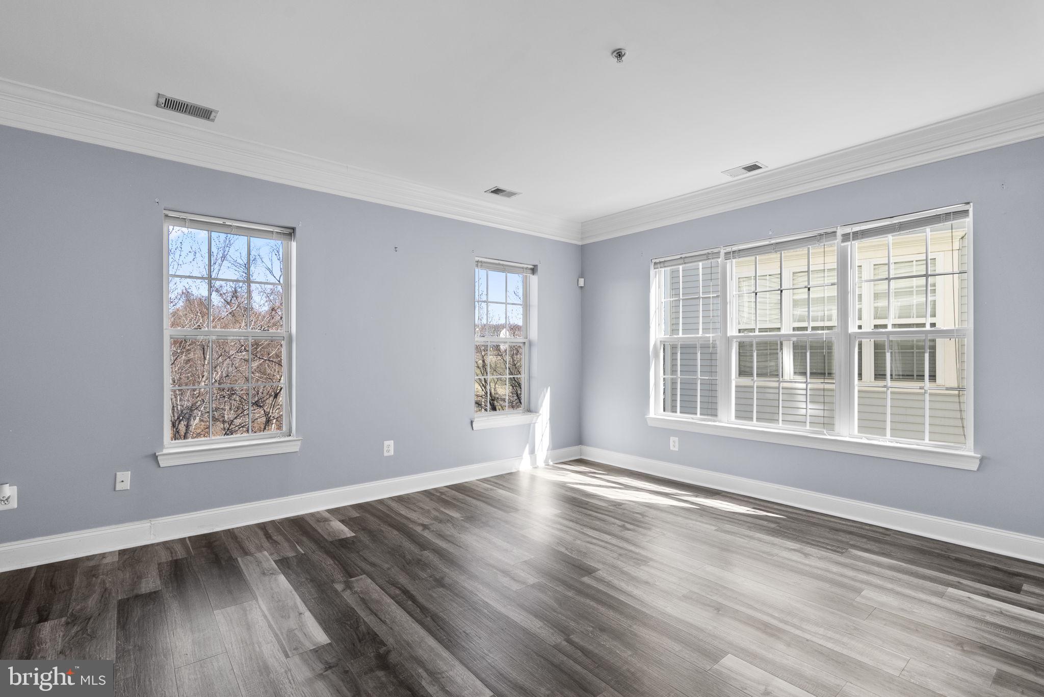 932 Orchard Ridge Drive, Unit 200 Gaithersburg, MD 20878 - Photo 6 of 51 a view of an empty room with wooden floor and a window