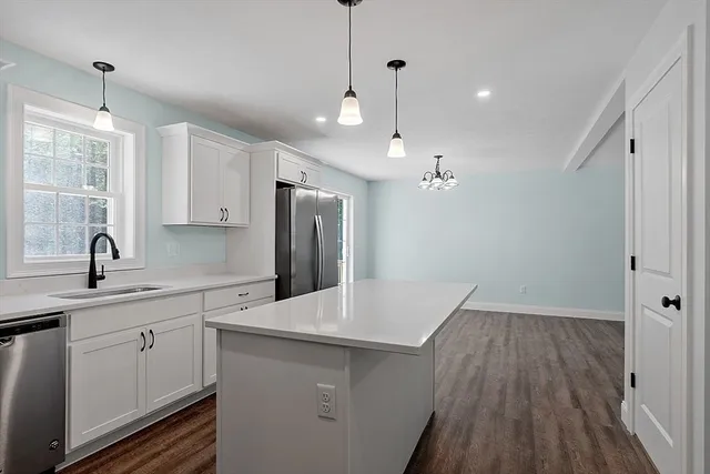 a kitchen with cabinets and wooden floor