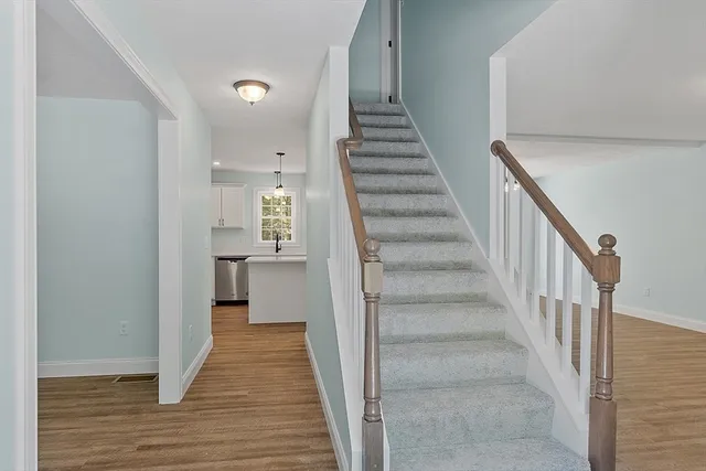 a view of a hallway with wooden floor and entryway